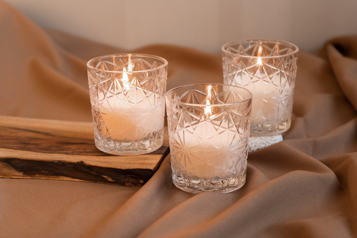 Lighted Candles on Wooden Board and Brown Silk